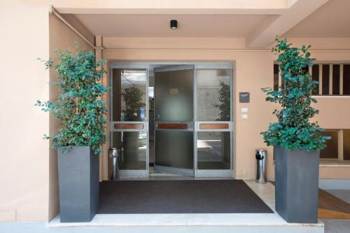 an entrance to an office building with two potted plants at Principessa Mafalda in Messina