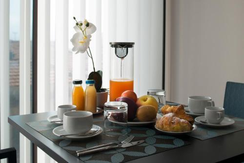 a table with a breakfast of fruit and orange juice at Principessa Mafalda in Messina