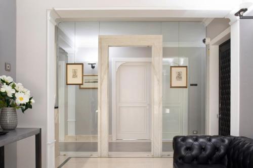 a room with a door and a black leather couch at Principessa Mafalda in Messina