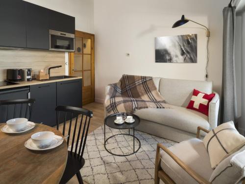 a kitchen and a living room with a table and a couch at La Résidence de L'Ours in Megève