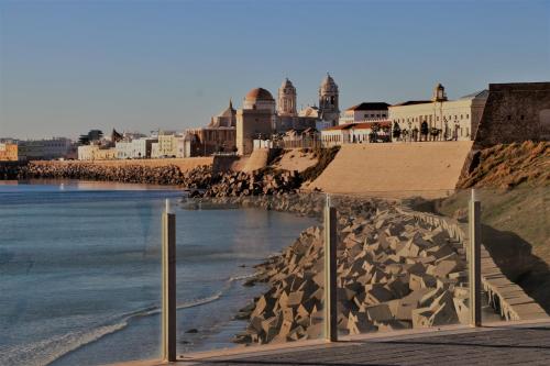 a beach with a bunch of rocks in the water at Apartamento Del Rio Playa in Cádiz