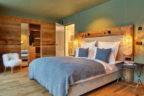 Schlafzimmer mit einem großen Bett mit einem Kopfteil aus Holz in der Unterkunft Mi Chalet in Stern