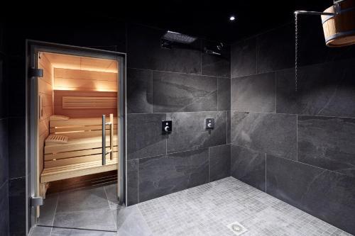 a bathroom with a walk in shower next to a tub at Novotel Suites Colmar Centre in Colmar