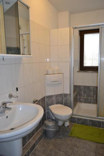 a bathroom with a sink and a toilet and a tub at Pension Highway Bünde in Bünde