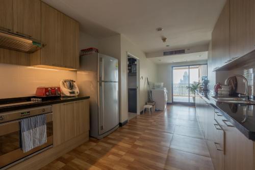 a kitchen with a refrigerator and a counter top at Somerset Park Suanplu Bangkok in Bangkok