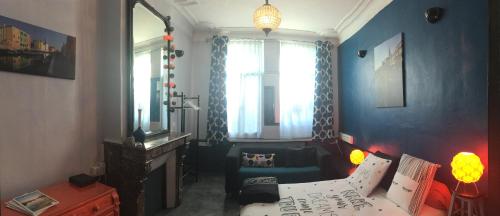 a living room with a couch and a mirror at La Maison Du Bulot in Fruges