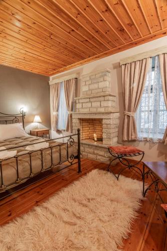 a bedroom with a bed and a fireplace at Guesthouse Selini in Vitsa
