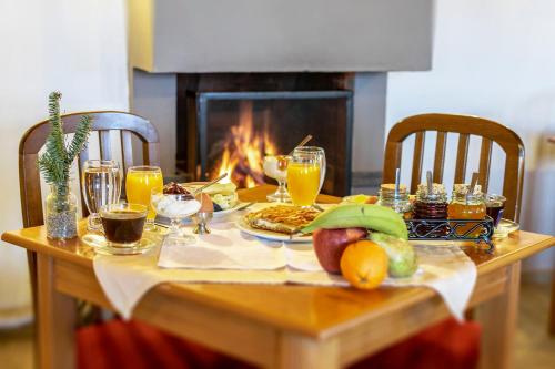 a table with food and drinks and a fireplace at Guesthouse Selini in Vitsa