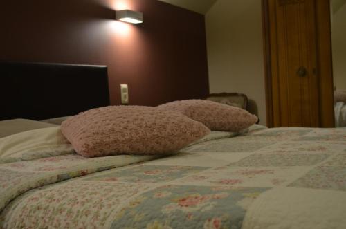 a bedroom with a bed with two pillows on it at B&B Hof Ter Haegen in Vollezele