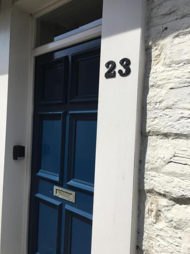 a blue door with the number on a building at The Attic Apartment, Quay Street Studios Cardigan in Cardigan