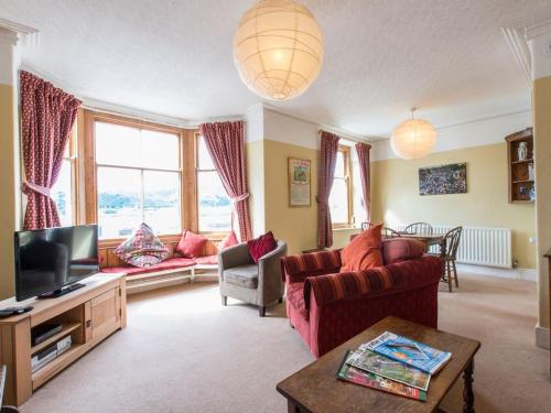 a living room with a couch and a tv at Glan Y Mor, 147 Station Road in Deganwy