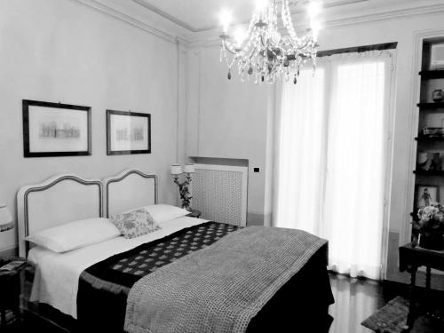 - une chambre avec un lit et un lustre dans l'établissement Bed and Breakfast Flowers, à Gênes