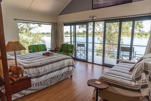 a bedroom with a bed and views of the water at Kayube Boat House in Livingstone