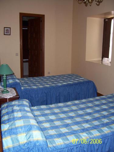 two beds in a hotel room with blue sheets at Las Medulas Los Telares in Las Médulas