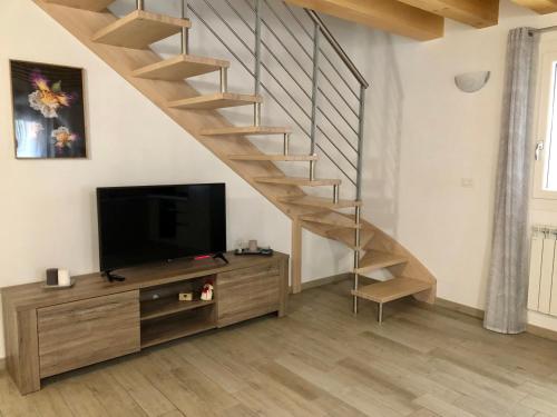 a living room with a tv and a staircase at Casa Sophy in Chioggia