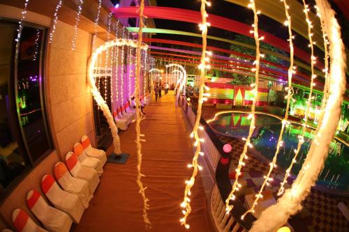 a walkway with christmas lights on the side of a building at Dhuri Resort in Vasai