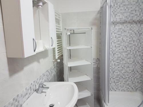 a white bathroom with a sink and a shower at Serafino Liguria Hotel in Genoa