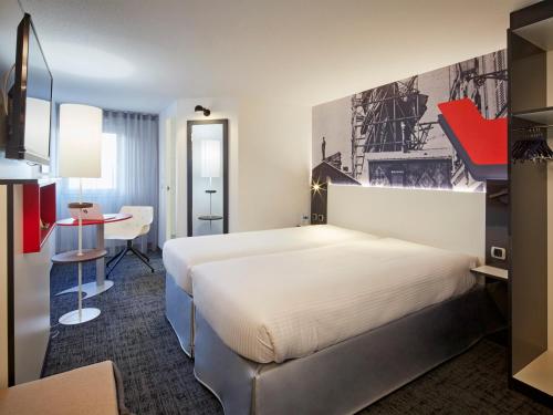 ein Hotelzimmer mit einem Bett und einem Schreibtisch in der Unterkunft Hôtel Gustave Colmar in Colmar