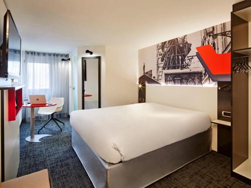 a hotel room with a large bed and a desk at Kyriad Colmar Centre Unterlinden in Colmar