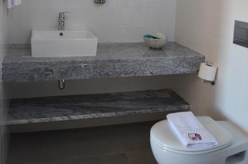 a bathroom with a sink and a toilet at Entre Vinhas & Mar in Óbidos
