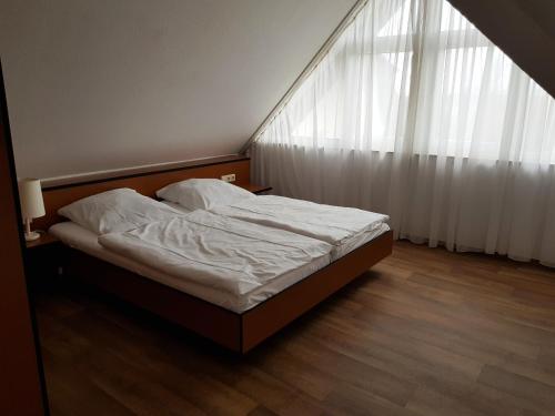 a bed in a bedroom with a large window at Fewo 18 im Strandhaus Lobbe mit Balkon in Lobbe