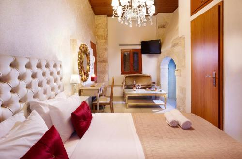 a bedroom with a bed and a chandelier at Archontiko Old Town Suites in Rethymno Town