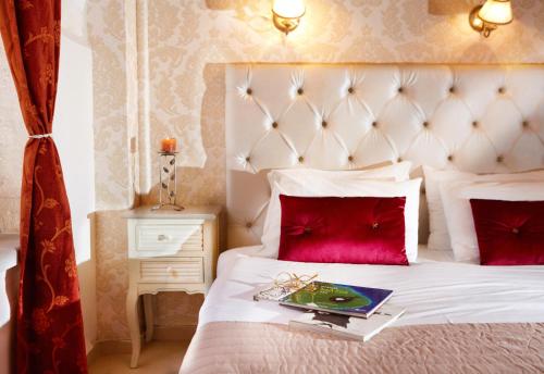 a bedroom with a white bed with red pillows at Archontiko Old Town Suites in Rethymno Town