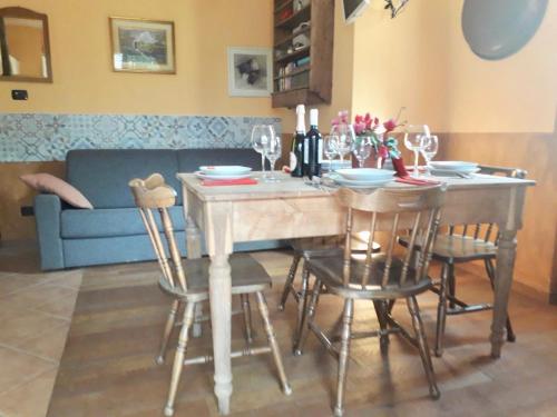 a dining room with a table with chairs and a couch at Casa Unica- da Bruno in Colico