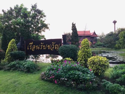 a sign in front of a pond in a garden at Rueanrubkwan in Ang Thong