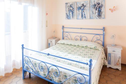 a blue bed in a room with windows at Eveten Apartments - Diano Marina in Diano Marina