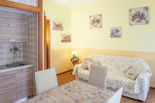 a small room with a bed and a table and chairs at Eveten Apartments - Diano Marina in Diano Marina