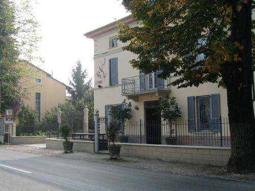 a white house with blue shutters and a fence at Hostaria Da Ivan in Roccabianca