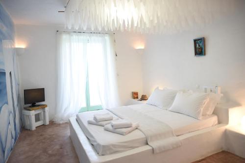 OtziásにあるOtzias green cottageの白いベッドルーム(白い枕の大きな白いベッド付)