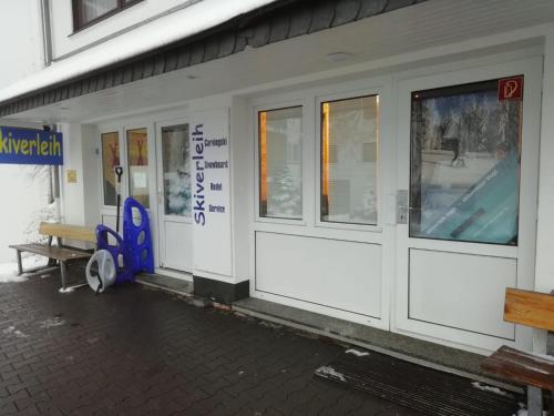 a white building with windows and a bench outside at Hotel Winterberg Resort in Winterberg