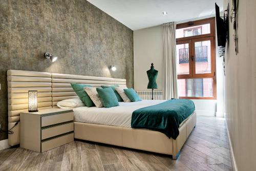 a bedroom with a large bed and a window at Apartamentos Cava Baja in Madrid