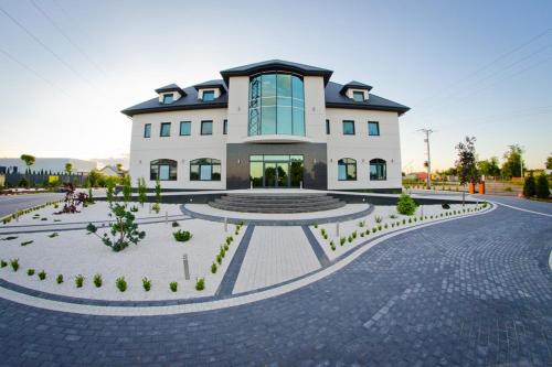 a large white building with a courtyard in front of it at Hotel Podkowa in Płock