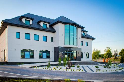 a large white building with a black roof at Hotel Podkowa in Płock
