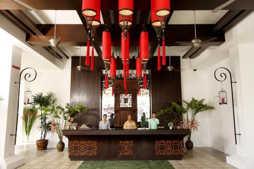 a lobby with a bar with red chandeliers at The Old Phuket - Karon Beach Resort - SHA Plus in Karon Beach