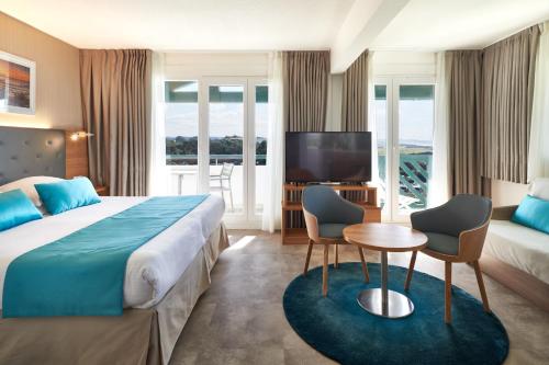a hotel room with a bed and a tv at Atlanthal in Anglet