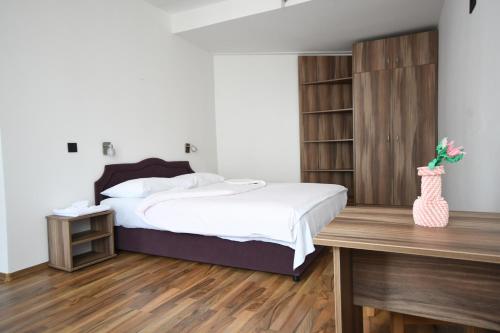 a bedroom with a bed and a wooden desk at Hotel Mladost in Tjentište