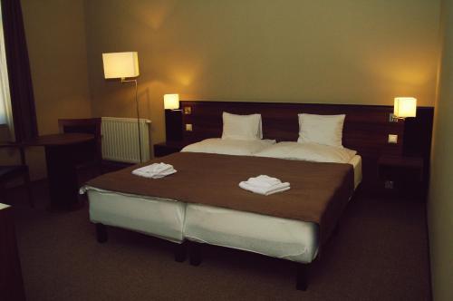 um quarto de hotel com uma cama com toalhas em Fiáker Panzió em Zalaszentgrót