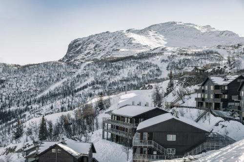 a resort in the snow with a mountain at Skarsnuten Apartments in Hemsedal