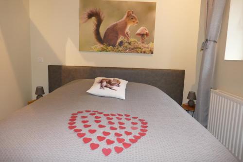 a bed with a heart with a squirrel on it at La Garonde in Berthen