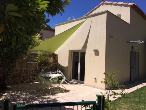 a building with a green awning in front of it at My Suit Home in Lunel