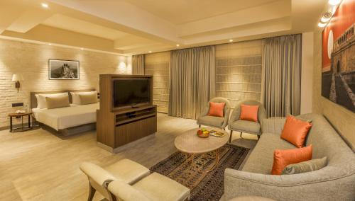 a living room with a couch and a television at Lemon Tree Premier City Center Pune in Pune