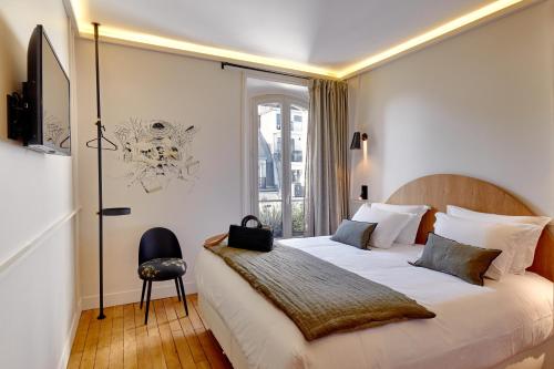 a bedroom with a large white bed with a window at Tinah Paris, Réaumur - Montorgeuil in Paris