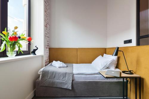 a bedroom with a bed with a laptop on a table at Ribas Rooms Ferenc Lviv in Lviv