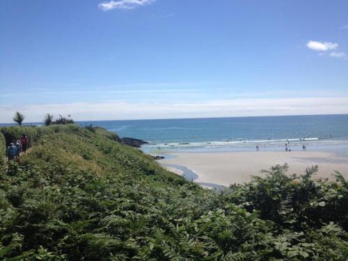 eine Gruppe von Menschen, die am Strand spazieren in der Unterkunft Inchydoney Apt 6, Block D in Clonakilty