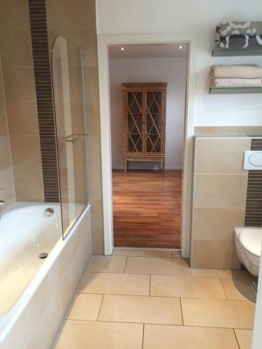 a bathroom with a tub and a toilet and a sink at Hof Busen Farm Haus in Mönchengladbach