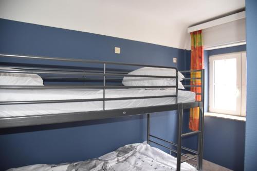 a bedroom with two bunk beds in a blue wall at Rust op de Kust - Villa 10 pers - 4 slpk - 2 badk in Middelkerke